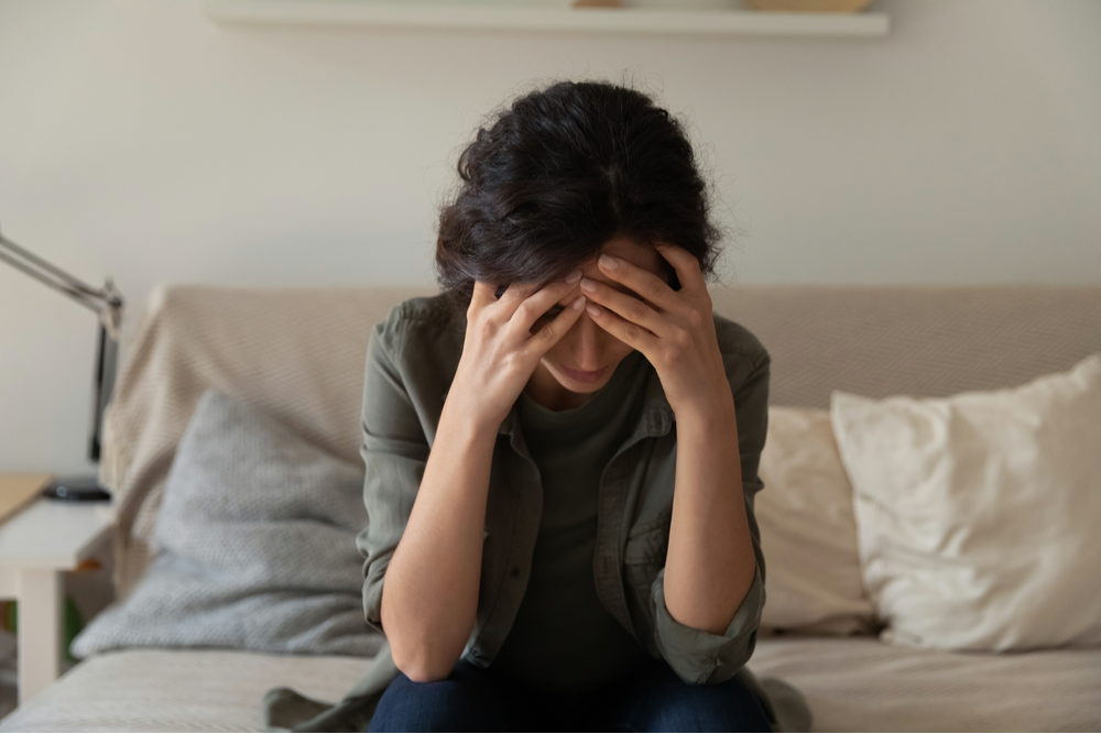 Woman holding head thinking "I relapsed today, now what?"