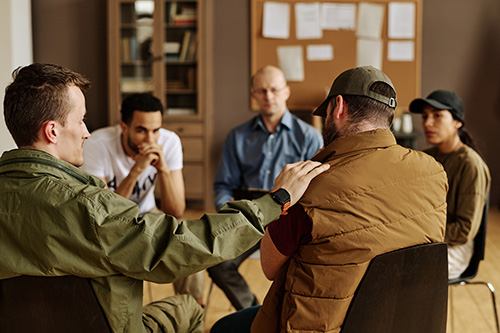 People sitting in a circle at a group therapy program